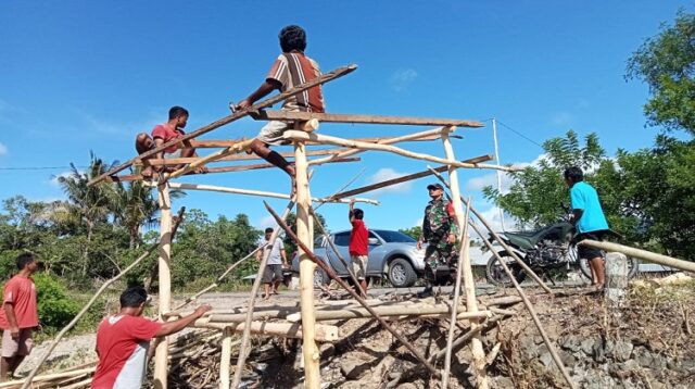 Mewujudkan Lingkungan Kondusif, Babinsa Koramil 06/Karera Bantu Warga Bangun Pos Kamling