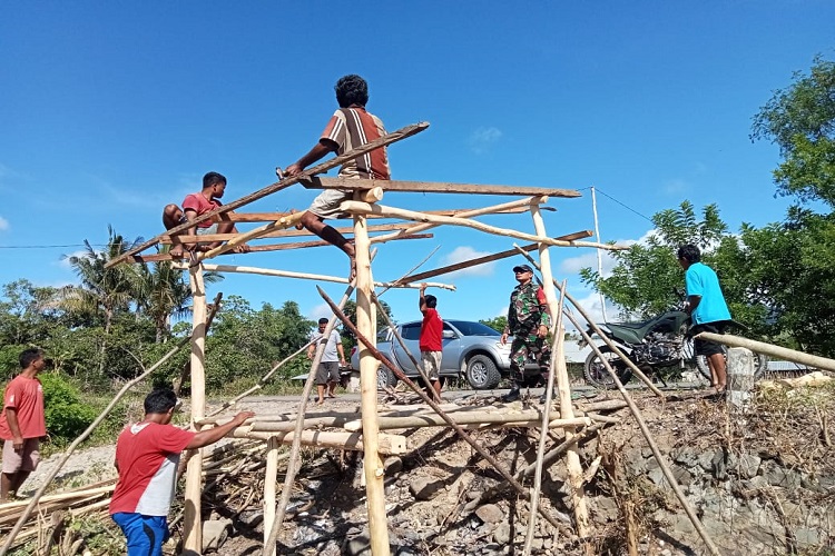 Mewujudkan Lingkungan Kondusif, Babinsa Koramil 06/Karera Bantu Warga Bangun Pos Kamling
