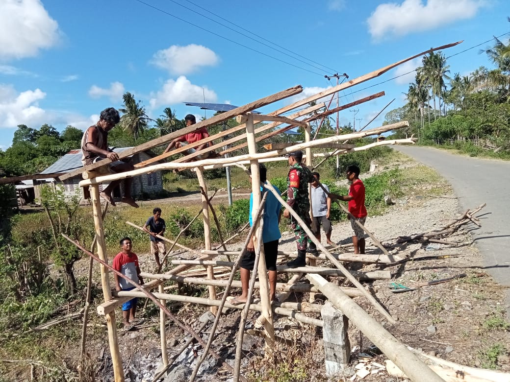 Mewujudkan Lingkungan Kondusif, Babinsa Koramil 06/Karera Bantu Warga Bangun Pos Kamling