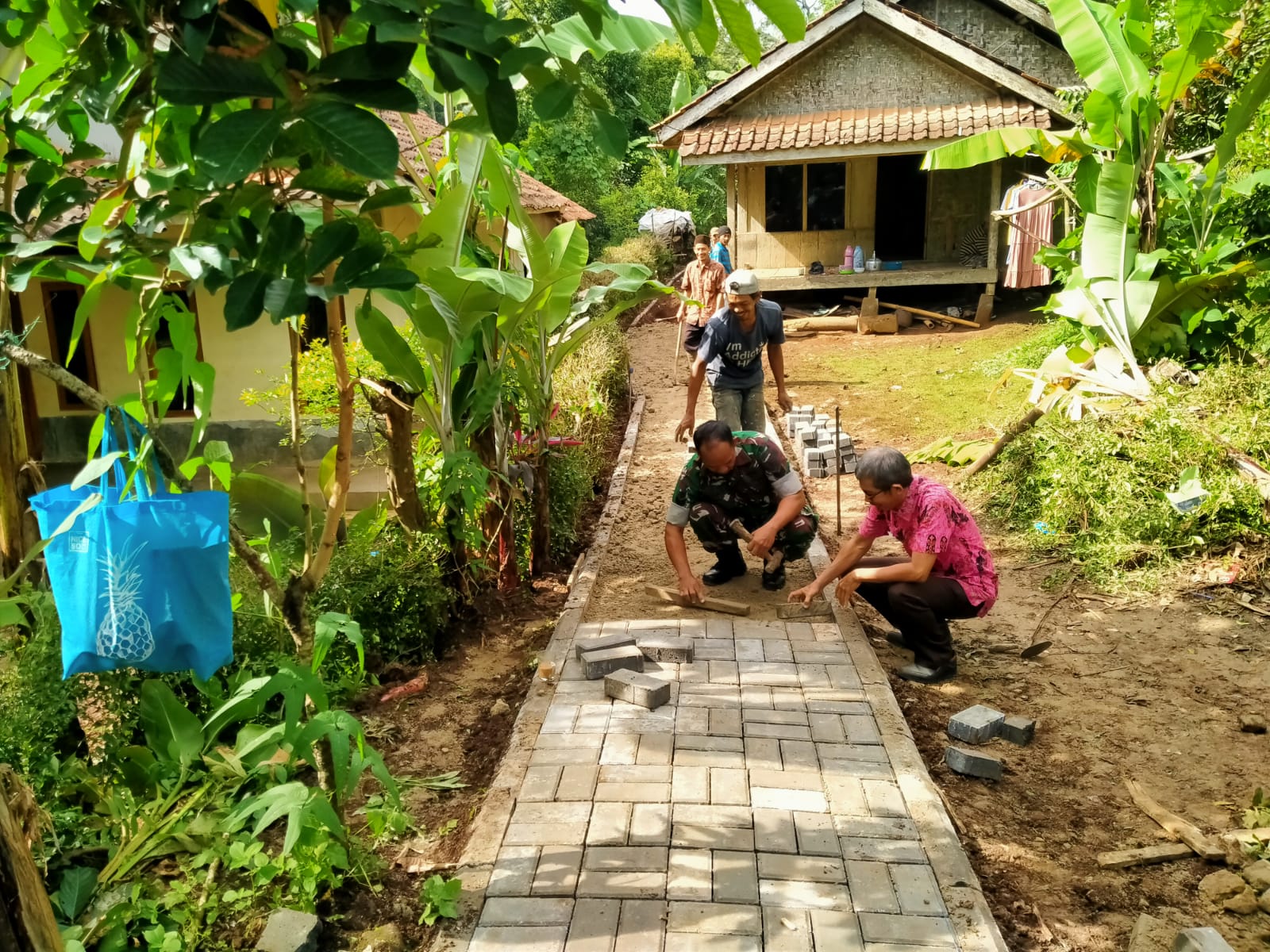 Tumbuhkan Semangat Gotong Royong, Babinsa Koramil 0102/Cadasari Batu Warga Pasang Paving Blok