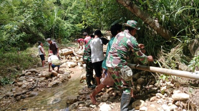 Babinsa Karera Dan Masyarakat Gotong Royong Perbaiki Pipa Air Bersih Yang Rusak Akibat Banjir
