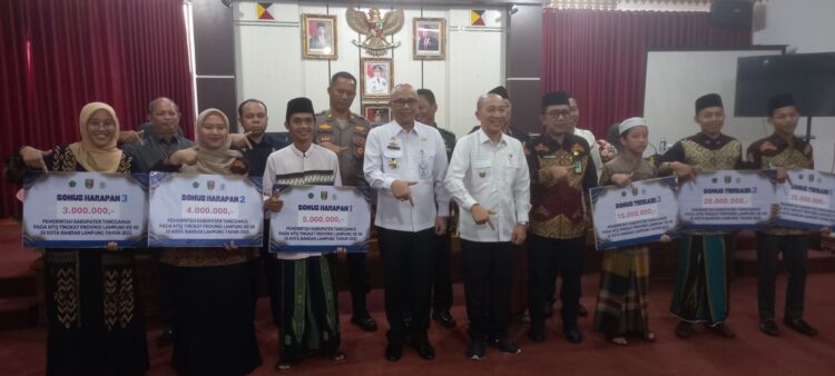Penjabat Bupati Tanggamus Ir. Mulyadi Irsan, Memberikan Bonus/Tali Asih Kafilah MTQ Kabupaten Tanggamus pada Event Musabaqoh Tilawatil Quran ke 50