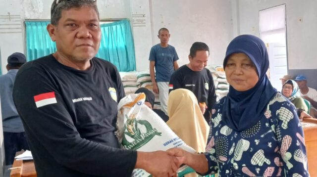 Pemdes Cipatujah Bersama Pihak Pos Menyalurkan Bansos Berupa Beras Di Gedung Aula Desa